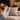 Person wearing cozy socks with a fireplace and Harris Tweed Duck Egg cushion in the background