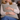 Woman holding a Harris Tweed Duck Egg cushion against her chest on a couch.