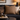 Cozy living room with a dark gray sofa, Harris Tweed Dunmore Houndstooth cushion and decorative items on a coffee table.