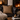 Cozy living room with a fireplace, leather sofa, and Harris Tweed Dunmore Houndstooth cushion.