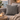 Cozy living room with a gray sofa, Harris Tweed Grey Herringbone cushion and a small table with a mug and candle.