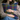Woman holding a colorful Harris Tweed Callanish Tartan cushion with a neutral background