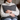 Woman holding a Harris Tweed Charcoal Herringbone cushion against a neutral background