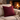 Harris Tweed Claret red cushion on a beige couch in front of a fireplace