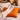 Person wearing cozy socks on a Harris Tweed Clementine orange cushion with a warm interior setting