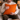 Man holding a Harris Tweed Clementine orange cushion in a cozy indoor setting