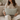 Woman holding a Harris Tweed Duck Egg lumbar cushion on a couch in a cozy living room.