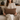 Woman holding a Harris Tweed Dunmore Houndstooth lumbar cushion on a couch in a cozy living room setting