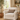 Beige armchair with a Harris Tweed Eriskay Herringbone lumbar cushion in a cozy living room setting.