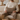 Man sitting on a couch holding a Harris Tweed Eriskay Herringbone lumbar cushion in a cozy living room setting.