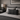 Grey upholstered bed with Birch Tartan Harris Tweed lumbar cushion and lamp on nightstand in bedroom setting
