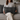 Woman holding a Birch Tartan Harris Tweed lumbar cushion on a couch