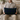 Man holding a Black Watch Harris Tweed lumbar cushion on a couch in a cosy living room.
