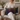 Woman holding a Harris Tweed Callanish Tartan cushion in a cozy living room setting.