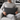 Man sitting on a couch holding a Harris Tweed Charcoal Herringbone lumbar cushion 