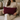 Woman holding a Harris Tweed Claret red lumbar cushion on a beige couch
