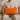 Man holding a Harris Tweed Clementine orange cushion on a beige couch