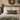 Bedroom with stone wall, wooden headboard, and Tweed Hazel Herringbone lumbar cushion.