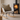 White rocking chair with a Harris Tweed Hazel Herringbone cushion in front of a lit wood stove.
