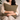 Woman holding a Harris Tweed Hazel Herringbone cushion on a couch