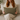Woman holding a Tweed Hazel Herringbone lumbar cushion on a beige couch