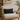 Beige armchair with a Harris Tweed Heather Glade Tartan lumbar cushion  in a cozy living room setting