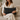 Woman holding a Harris Tweed Heather Glade Tartan lumbar cushion on a beige couch