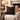 Cream armchair with a Harris Tweed Heather Glade cushion, in a cosy sitting room