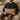 Man sitting on a couch holding a Harris Tweed Latte lumbar cushion in a cozy living room setting.