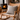 Wooden rocking chair with a Harris Tweed Light Grey Marl cushion in front of a fireplace.