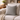 Harris Tweed Light Grey Marl cushion on a beige sofa with a cozy blanket and decorative items in the background