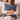 Woman holding a Harris Tweed Lomond Barleycorn cushion  on a beige couch