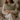 Woman sitting on a couch holding a Harris Tweed Lovat Herringbone cushion wearing a cozy sweater and pants.