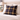 Harris Tweed MacKenzie Tartan cushion on a bed with a lamp and flowers in the background