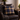 Harris Tweed MacKenzie Tartan cushion on a brown leather armchair with a gray blanket in a cozy living room.