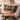 Woman holding a Harris Tweed MacLeod Tartan cushion  on a couch