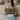 Woman holding a Harris Tweed MacLeod Tartan lumbar cushion on a couch in a cozy living room.