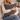 Woman holding a tHarris Tweed Grey Marl cushion on a couch