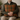 Man holding a Harris Tweed Moss, Gingerbread & Wine cushion on a couch in a cozy indoor setting