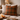 Harris Tweed Moss, Gingerbread & Wine cushion on a sofa with candles and a lamp in a cozy living room.
