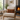 Cozy living room with a beige armchair, Harris Tweed Moss, Gingerbread & Wine lumbar cushion and a fireplace.