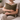 Woman sitting on a couch holding a Harris Tweed Moss cushion