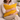 Woman holding a Mustard yellow Harris Tweed cushion on a couch in a cozy living room setting