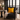 Grey armchair with a Mustard yellow Harris Tweed cushion in a room with large windows showing a cityscape.
