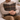 Man holding a Harris Tweed Oakwoods Tartan cushion on a couch