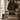 Wooden bench with Harris Tweed Oakwoods Tartan lumbar cushion, coat, boots, and bag in a rustic interior setting.