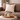 Brown sofa with a Harris Tweed Oatmeal cushion and a small table with a cup, candle, and decorative items.