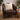 Brown leather armchair with a Harris Tweed Oatmeal cushion in a home setting with plants and a candle.