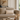 Beige sofa with Harris Tweed Oatmeal lumbar cushion and a small table with candles and a vase in a living room setting.