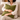 Woman holding a Harris Tweed Olive cushion, on a couch